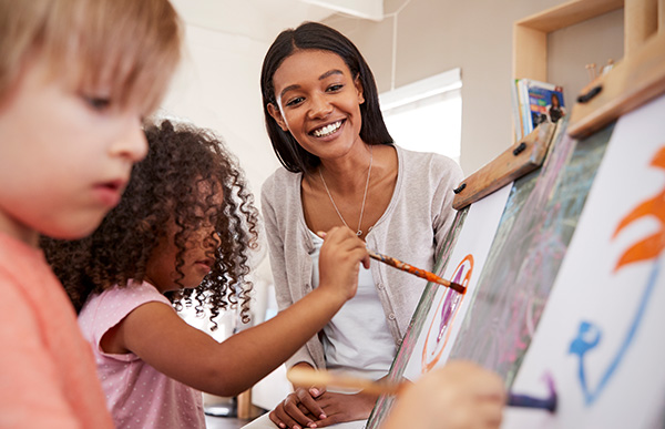 Smiling teacher working with children