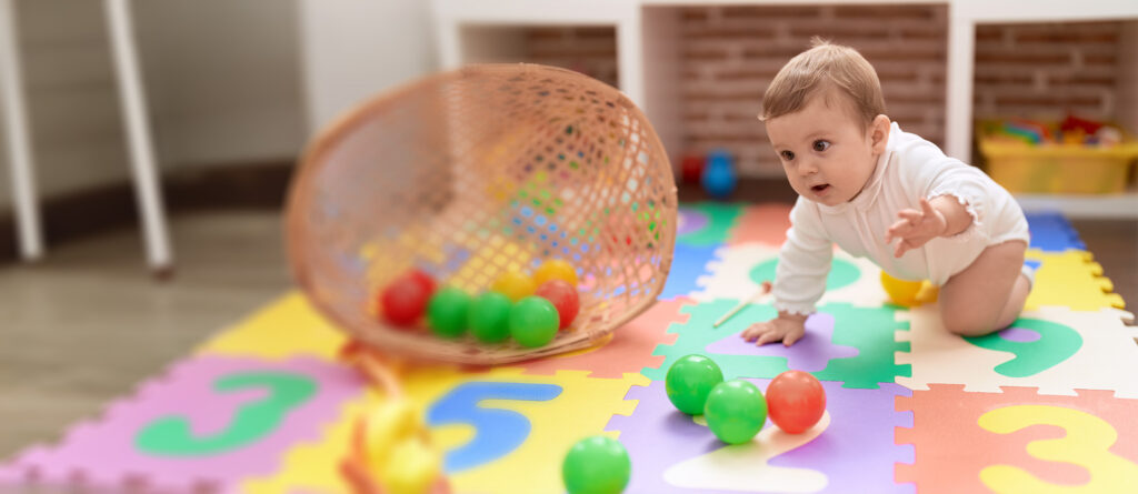 Crawling infant playing with colorful toys