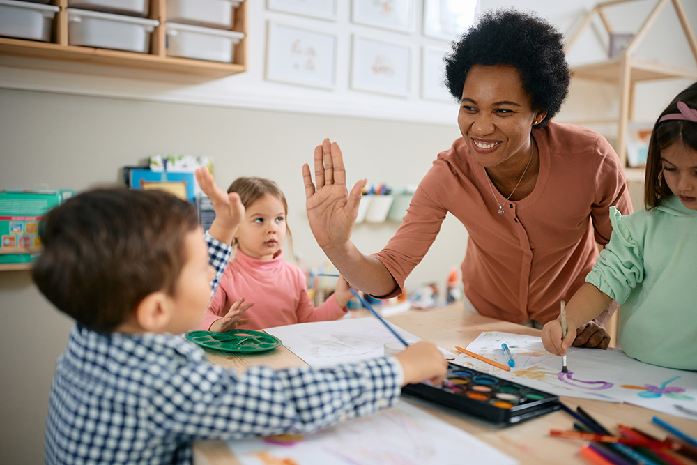 Teacher hi-fiving a student