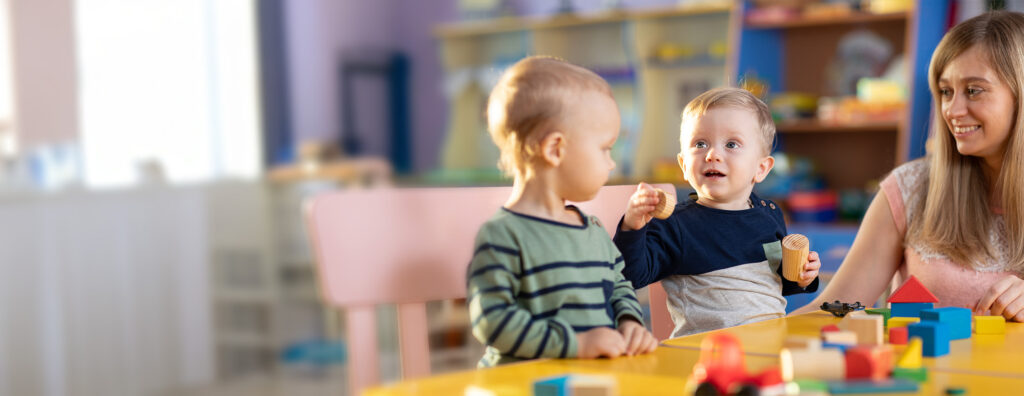 Toddlers and a teacher playing with blocks