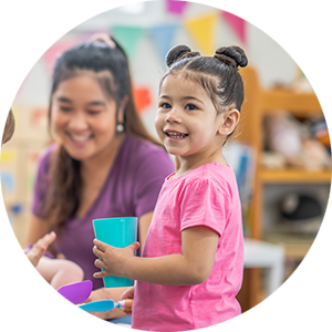 Smiling child holding a blue cup