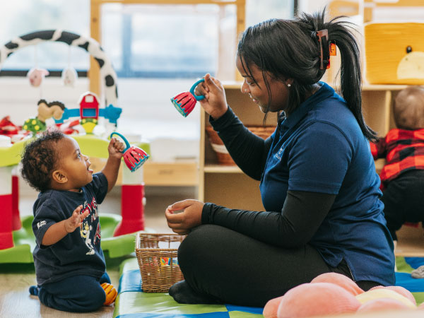 Teacher rattling toy in air for infant child