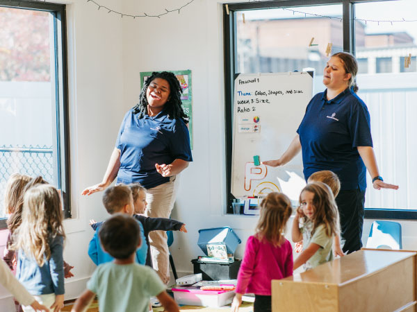 Two teachers in front of children in classroom