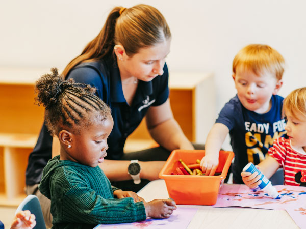 Teacher working with boy and girl at table