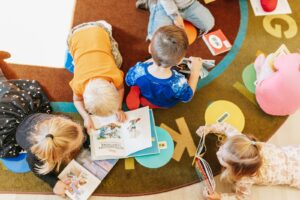 Children laying on ground looking at books