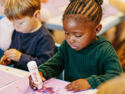 Young girl drawing art on paper in classroom