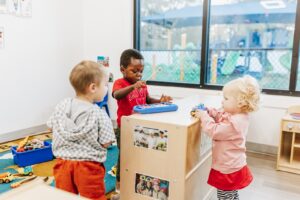 Three toddler children playing with activities