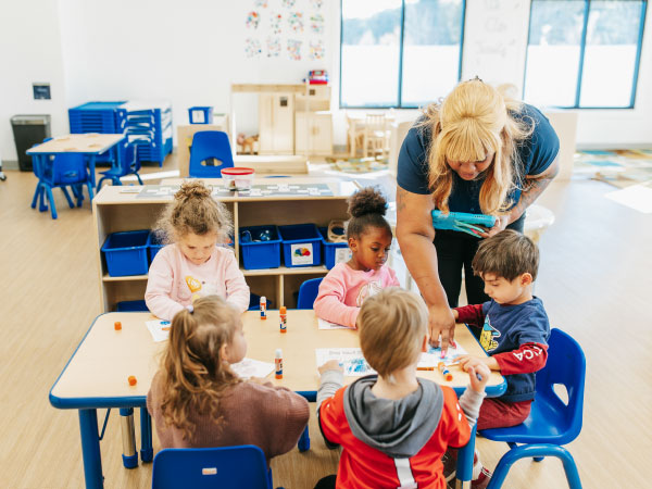 Teacher working with children sitting at table